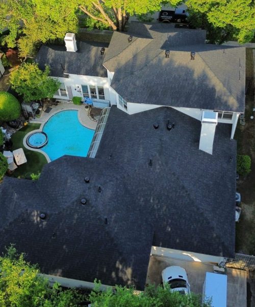 Residential roofing contractor inspecting a hail-damaged roof in North Texas
