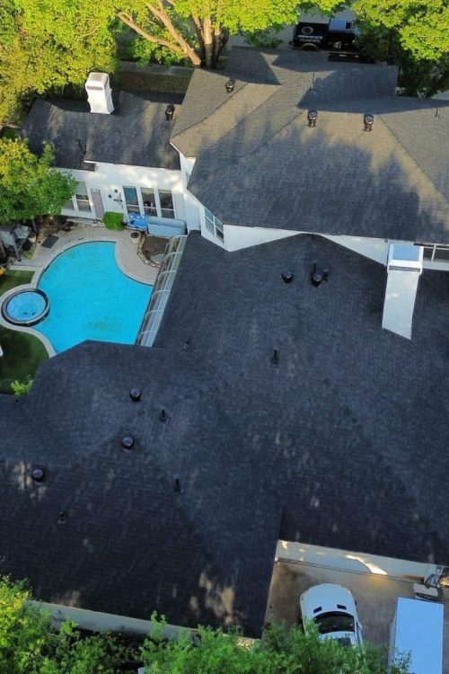 Residential roofing contractor inspecting a hail-damaged roof in North Texas